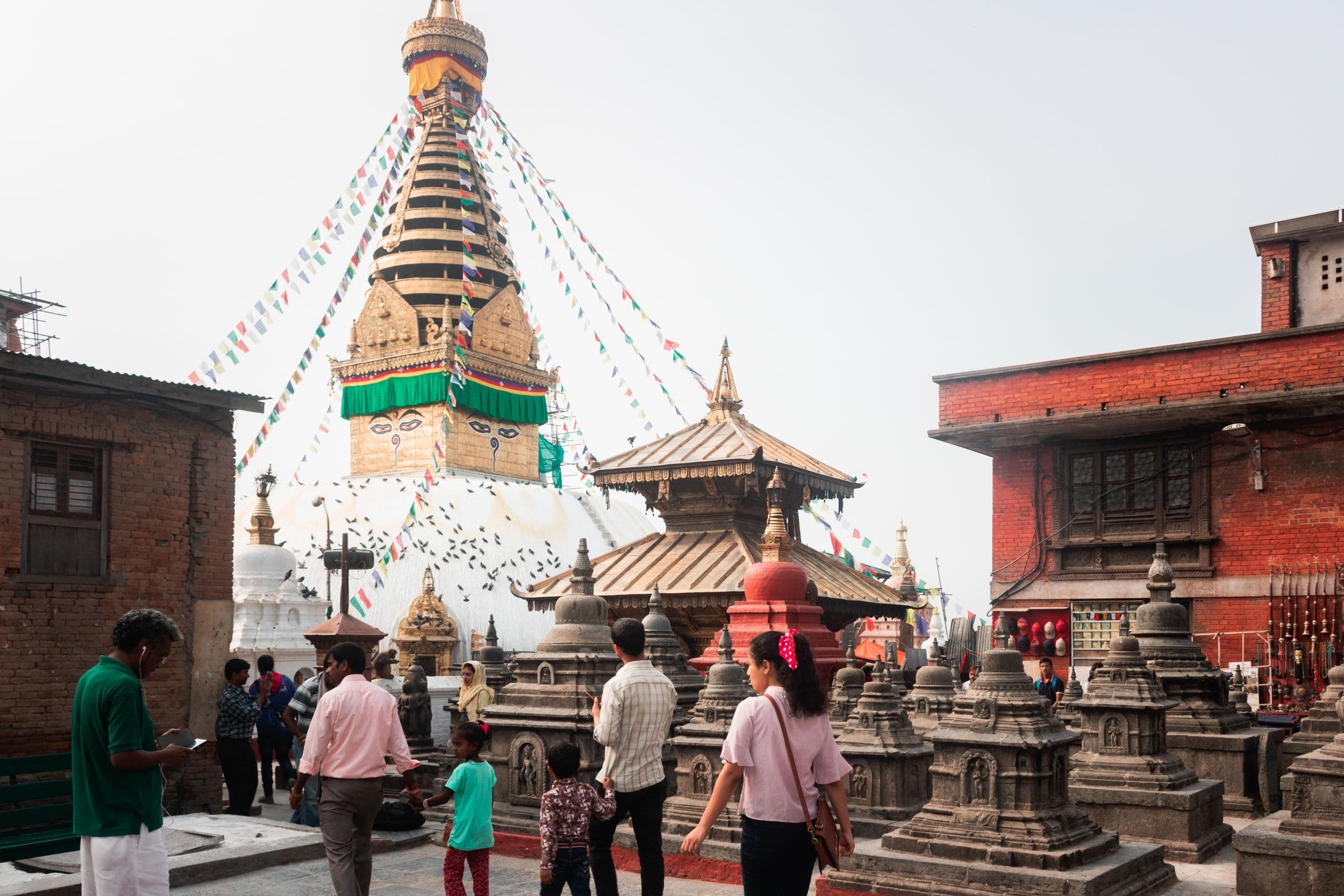 Visitors crowded around the magnificent Boudhanath Stupa adorned with prayer flags in Kathmandu.