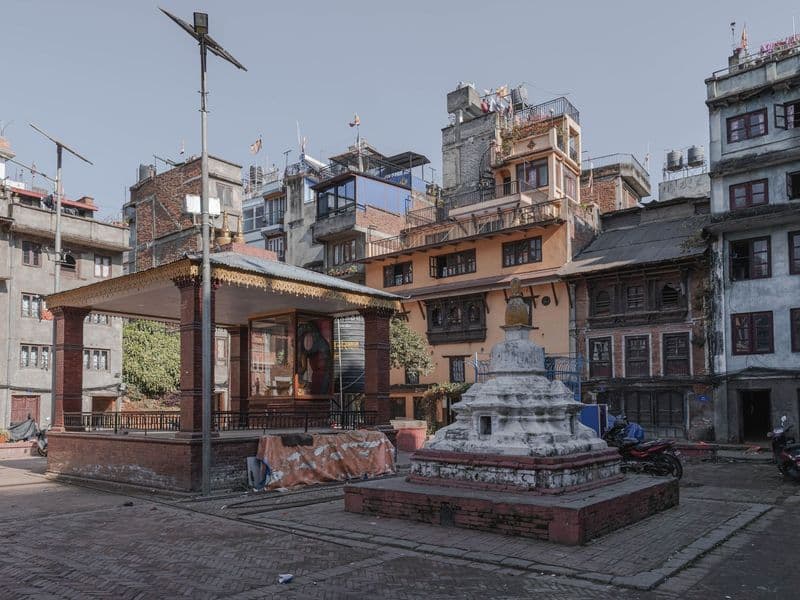 Quaint square in Kathmandu featuring a stupa and traditional Nepali architecture.