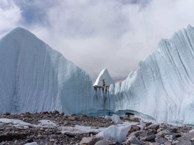 A lone climber atop stunning ice formations, capturing the beauty of winter's frozen landscapes.