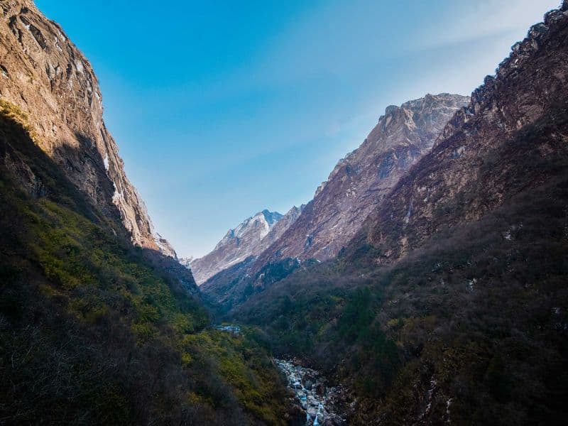 Stunning view of Deurali valley in the Himalayas, showcasing rugged landscapes and blue skies.