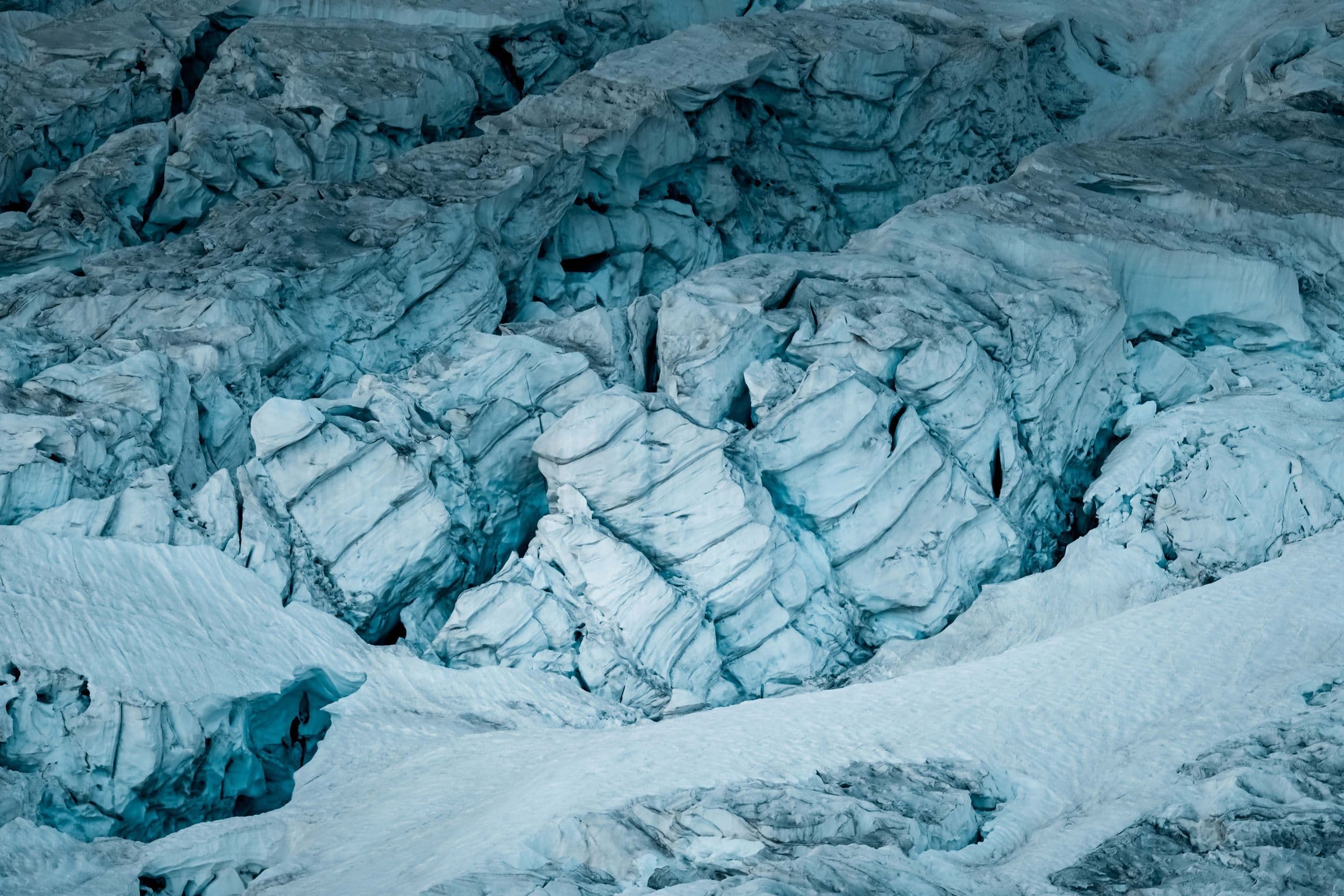 Stunning aerial capture of a striking glacier with deep icy crevices and snow-covered surface.