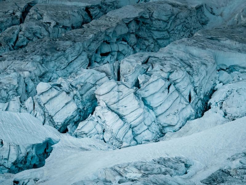 Stunning aerial capture of a striking glacier with deep icy crevices and snow-covered surface.