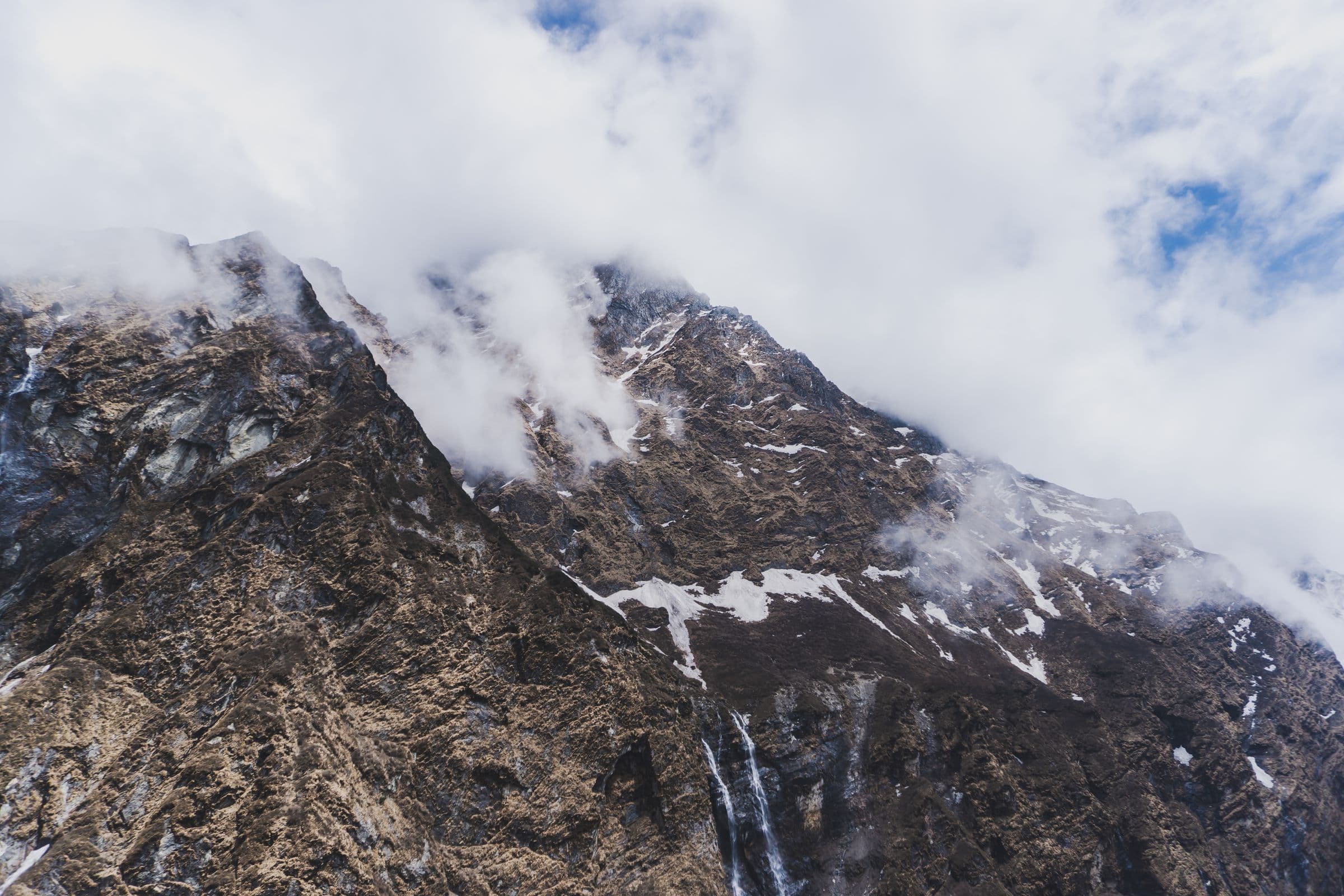 Dramatic view of Himalayan peak with clouds in Ghandruk, Nepal, perfect for travel and adventure themes.