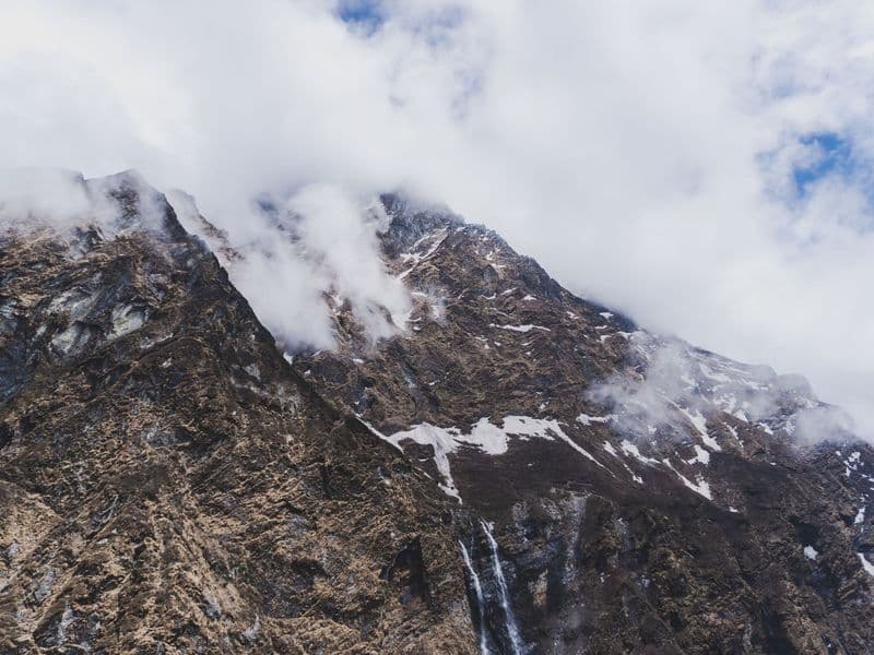 Dramatic view of Himalayan peak with clouds in Ghandruk, Nepal, perfect for travel and adventure themes.