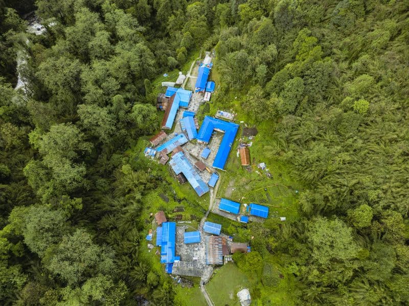 Explore Ghandruk, Nepal from above. This vibrant village is nestled in dense forests, showcasing stunning architecture.